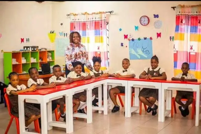 A Grade School class at their desks with their teacher, under colourful classroom displays