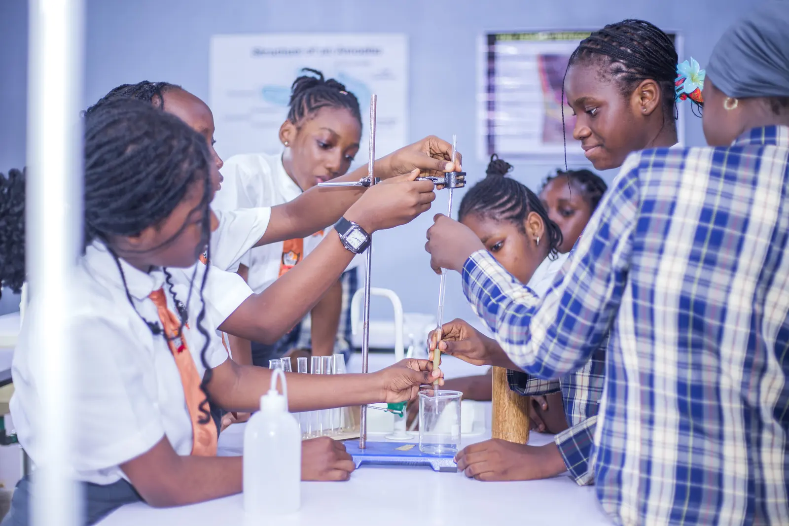 Students and younger pupils working with test tubes together in the science laboratory