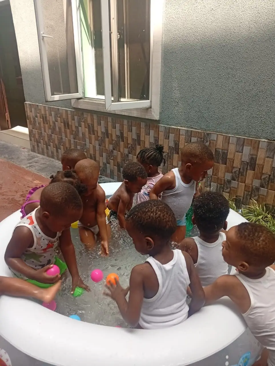 Young pupils playing in a paddling pool on Beach Party Day
