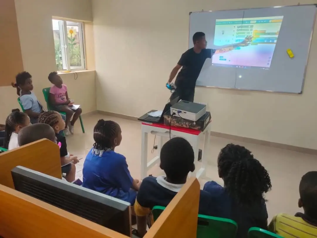 A teacher showing a coding project on the projector screen to a class