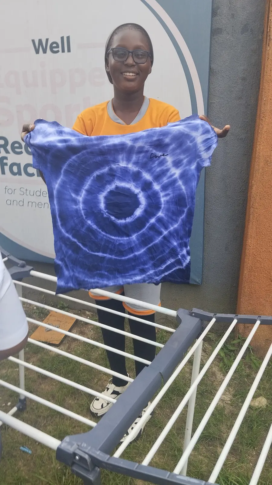 A pupil holding up a blue tie-dyed T-shirt
