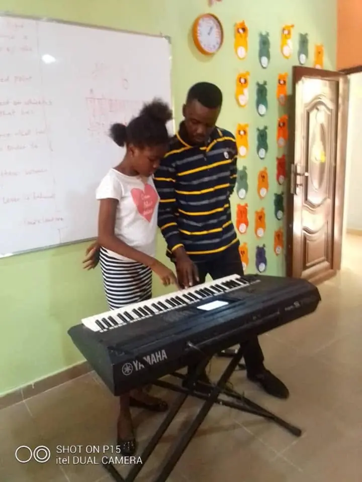 A pupil learning the keyboard with a music teacher
