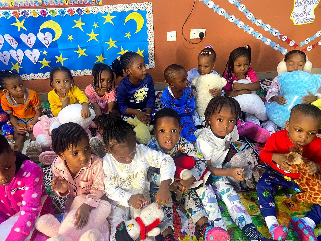 Pre-School children in pyjamas with their teddy bears at a class pyjama party