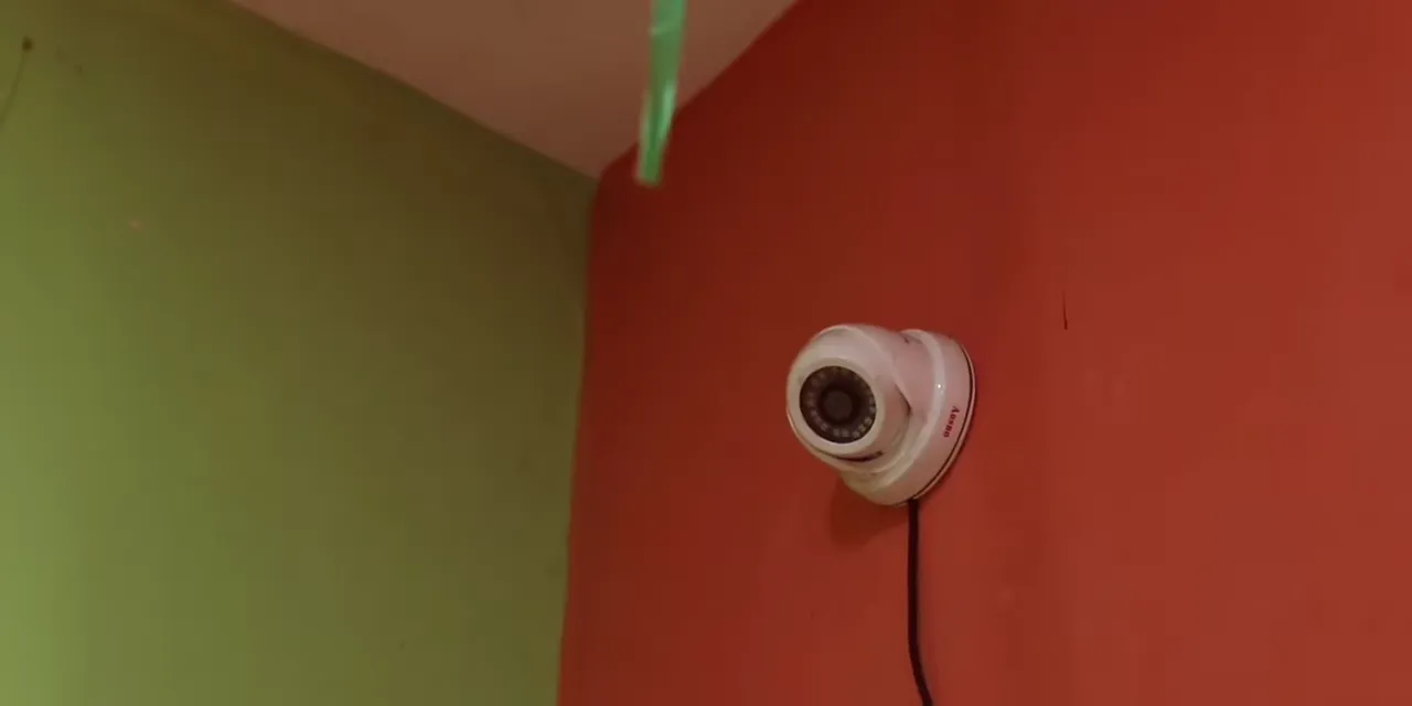 A CCTV camera mounted high on a classroom wall