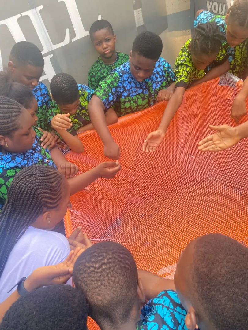 Pupils gathered round the school's fish pond during a fishery lesson