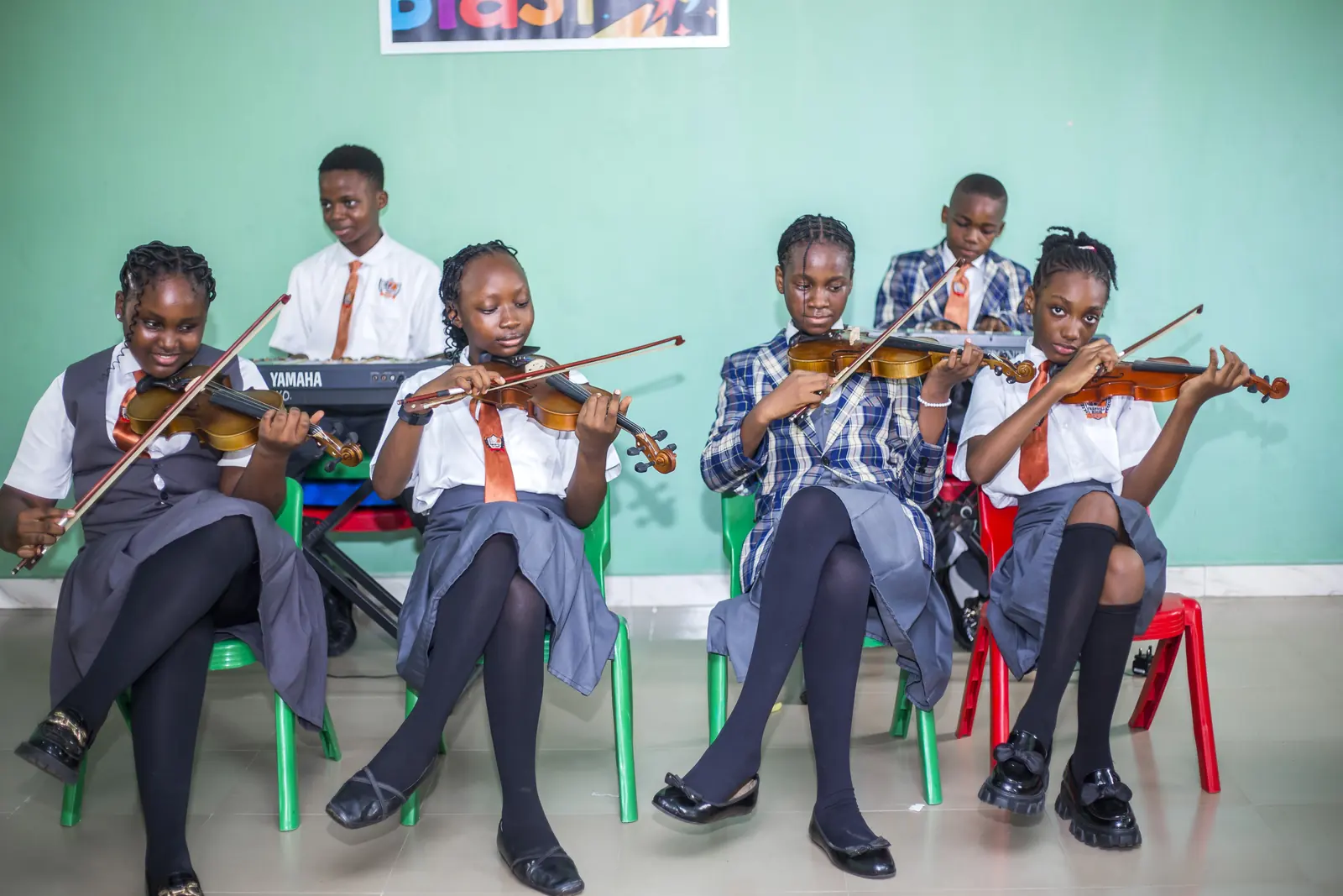 Students playing violins together in the music studio