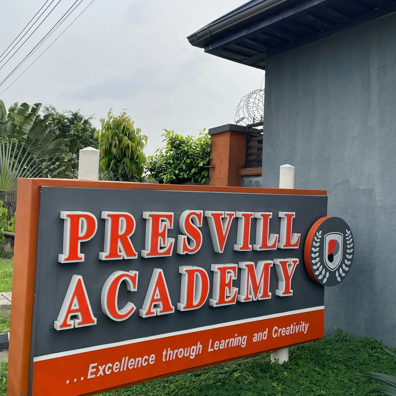 The Presvill Academy signboard, with the crest and the words “Excellence through Learning and Creativity”